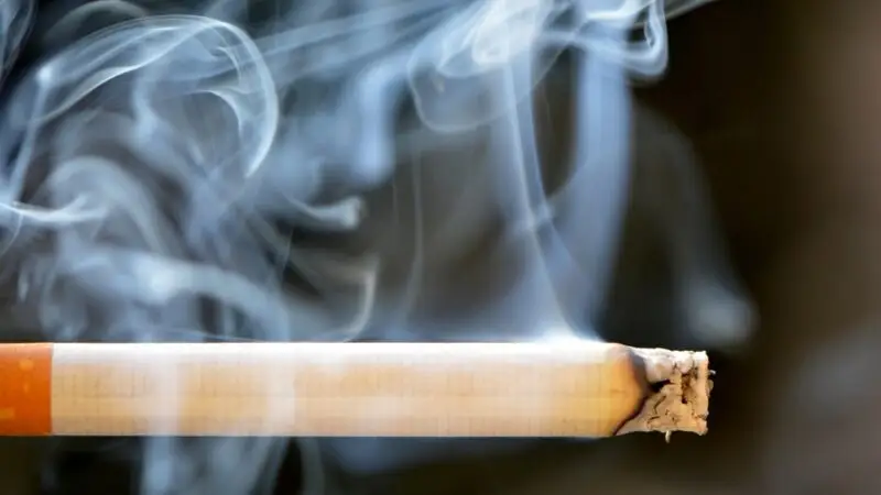 Imagem de cigarro queimando em destaque